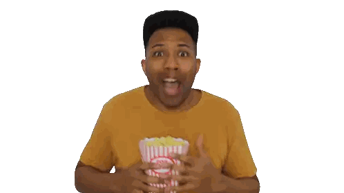 Man in Yellow Shirt Eating Popcorn From Striped Bucket