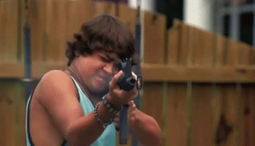 Man in Yellow Shirt Holding Gun Next to Boy in Blue Shirt