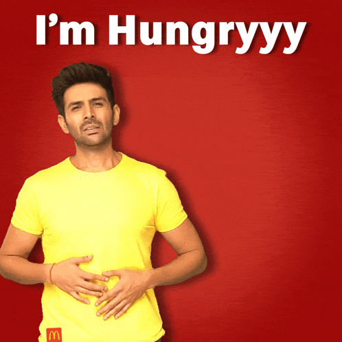 Man in Yellow Shirt Holding Stomach I'm Hungryyy
