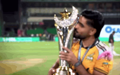 Man in Yellow Shirt Holding Trophy