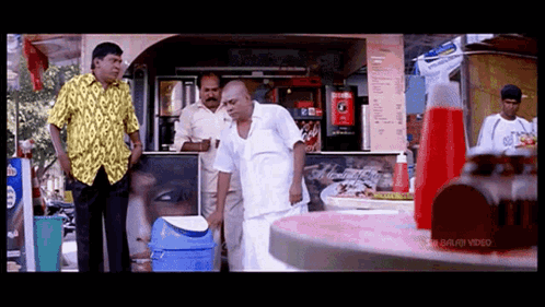 Man In Yellow Shirt In Front Of Coca Cola Machine GIF