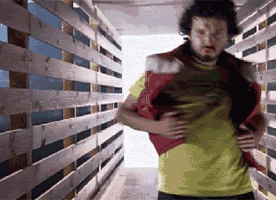 Man in Yellow Shirt in Wooden Hallway
