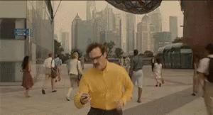 Man in Yellow Shirt Running Looking at Cell Phone