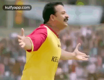 Man in Yellow Shirt Standing Before Crowd With Hands Outstretched