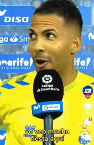 Man in Yellow Shirt Talking Into Microphone Yo Veo Mucha Fiesta Aqui