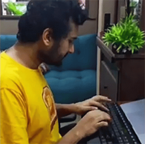 Man in Yellow Shirt Typing on Keyboard