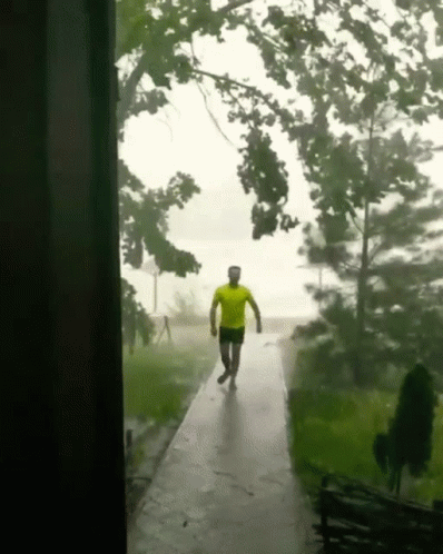 Man In Yellow Shirt Walking In Rain GIF