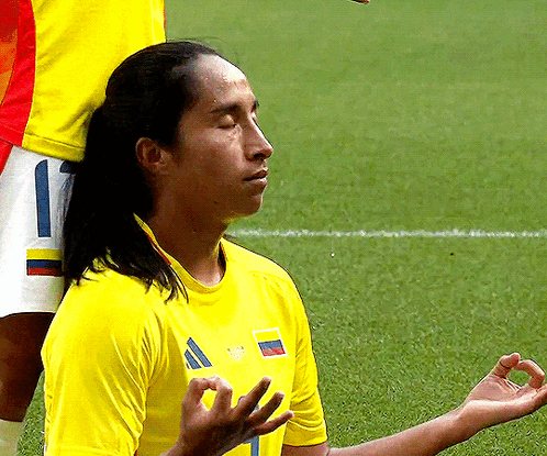 Man in Yellow Shirt With Number 1 Meditating