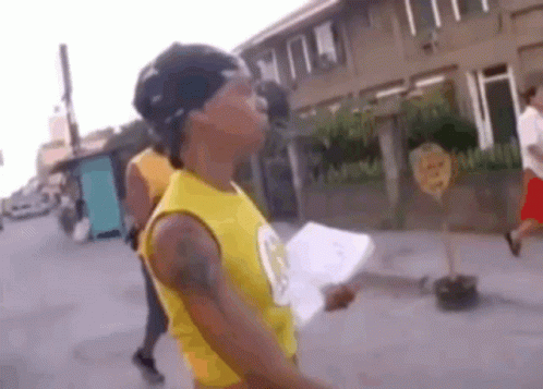 Man In Yellow Tank Top Holding Paper GIF