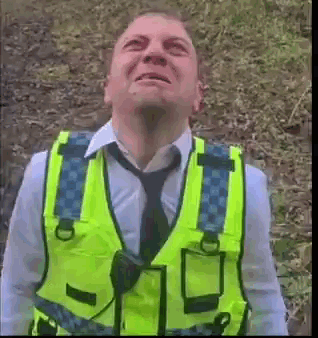 Man in Yellow Vest Looking Up at Sky