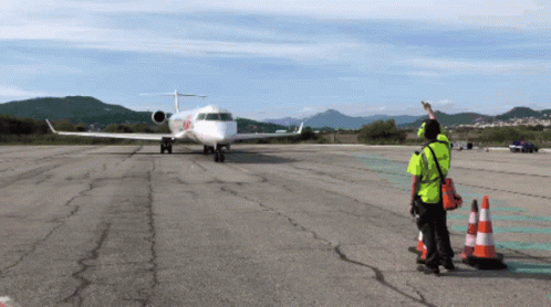 Man in Yellow Vest Next to Plane with X