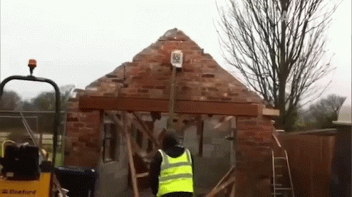 Man In Yellow Vest Standing Before Construction GIF