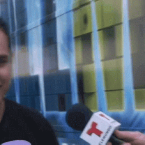 Man Interviewed by Person With Red T Microphone