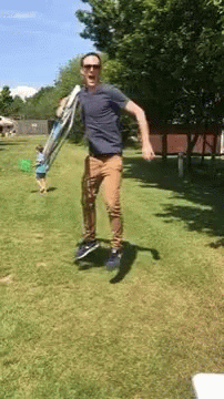 Man Jumping Holding Ladder In Park GIF