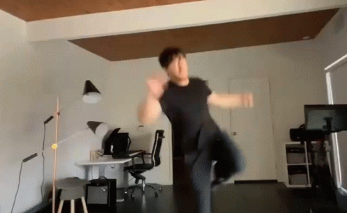 Man Jumping in Room with Desk and Chair