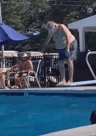 Man Jumping Into Pool While Another Sits On Chair GIF