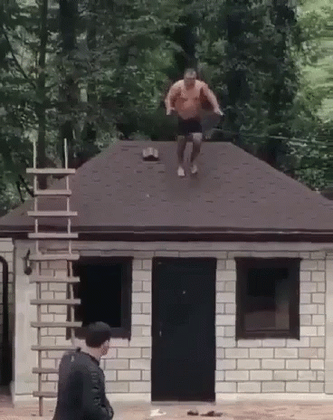 Man Jumping Off Brick Building Roof GIF