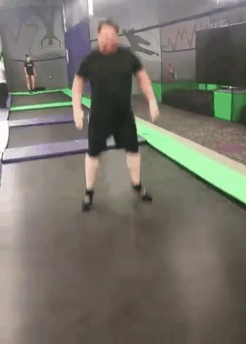 Man Jumping on Trampoline with Another Watching