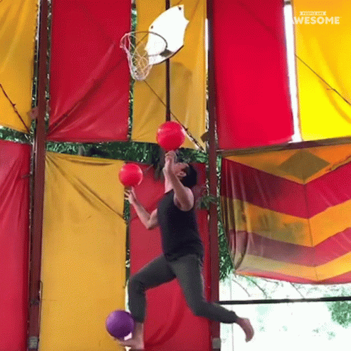 Man Jumping Through Basketball Hoop Holding Two Balls Saying Awesome