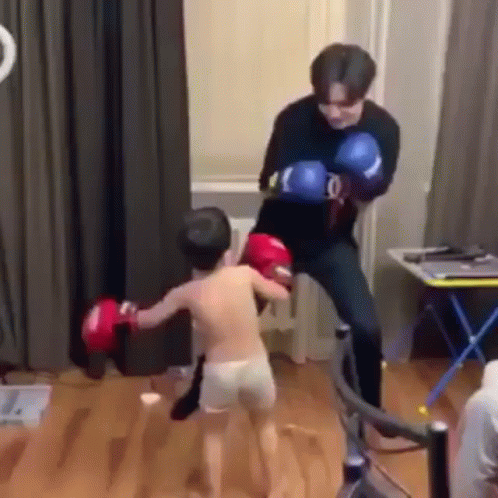 Man Kicking Boy in Face With Boxing Gloves