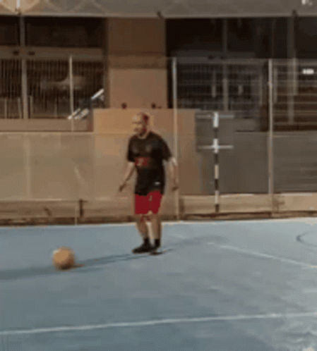 Man Kicking Soccer Ball On Blue Court GIF