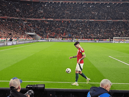 Man Kicking Soccer Ball on Field With Hungary