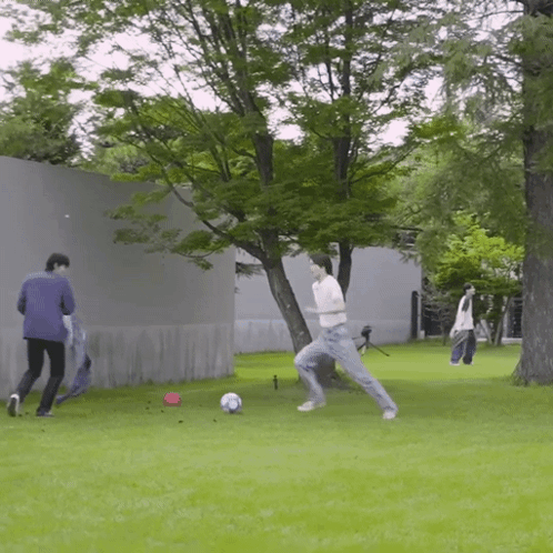 Man Kicking Soccer Ball While Another Watches