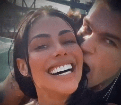 Man Kissing Smiling Woman on Cheek