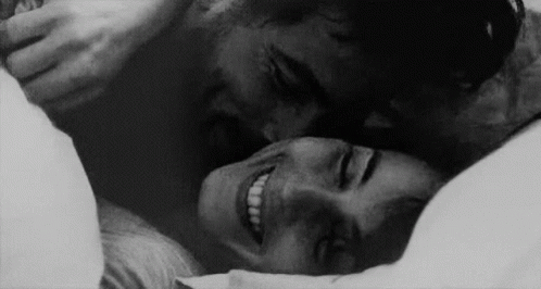 Man Kissing Woman On Forehead In Bed GIF