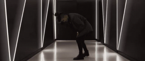 Man Kneeling in Dark Hallway with Lines