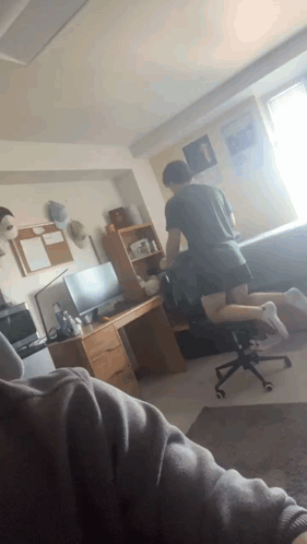 Man Kneeling in Room With Desk and Chair