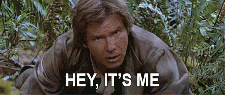 Man Kneeling in Woods Saying Hey