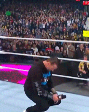 Man Kneeling in Wrestling Ring Holding Camera