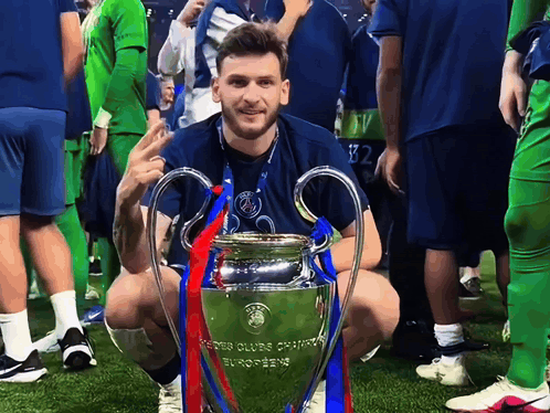 Man Kneeling Next To Champions League Trophy GIF