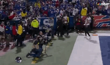 Man Kneeling on Football Field During Game