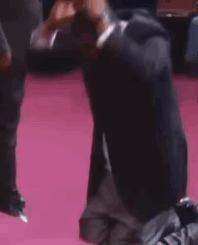 Man Kneeling on Pink Carpet