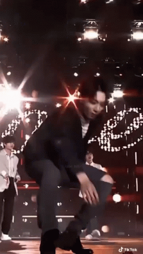 Man Kneeling on Stage in Front of Crowd