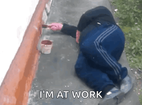 Man Kneeling Painting Wall Saying I'm at Work