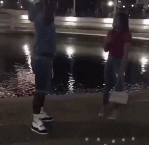 Man Kneeling Proposing to Woman in Front of Fountain