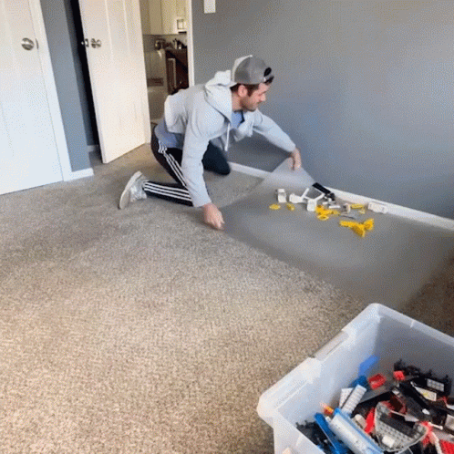 Man Kneeling with Box of Lego Bricks