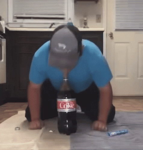 Man Kneeling With Coke Bottle