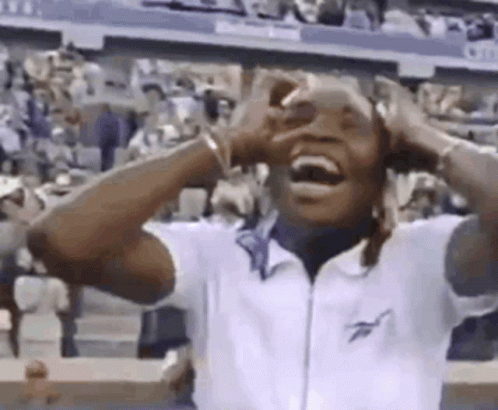Man Laughing Hands on Head in Crowd at Tennis Match