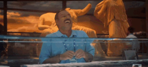 Man Laughing in Front of Statue