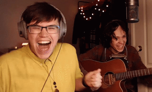 Man Laughing with Headphones and Guitar