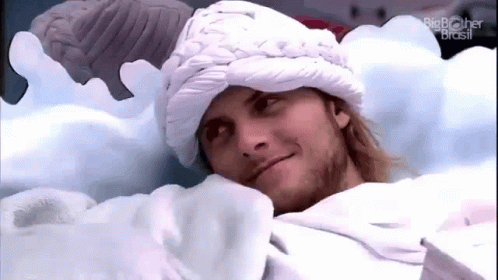 Man Laying in Bed Wearing White Hat