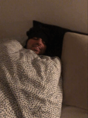 Man Laying in Bed With Leopard Print Blanket