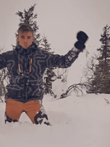 Man Laying in Snow With Arms Up