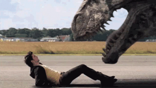 Man Laying Next To Dinosaur GIF