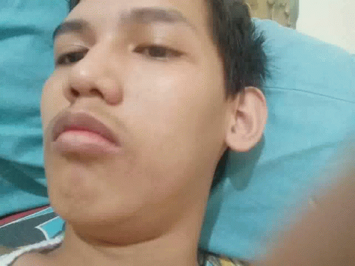 Man Laying on Bed Making Funny Face
