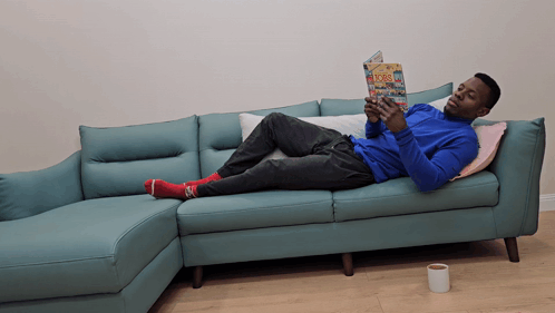 Man Laying On Couch Reading Book GIF